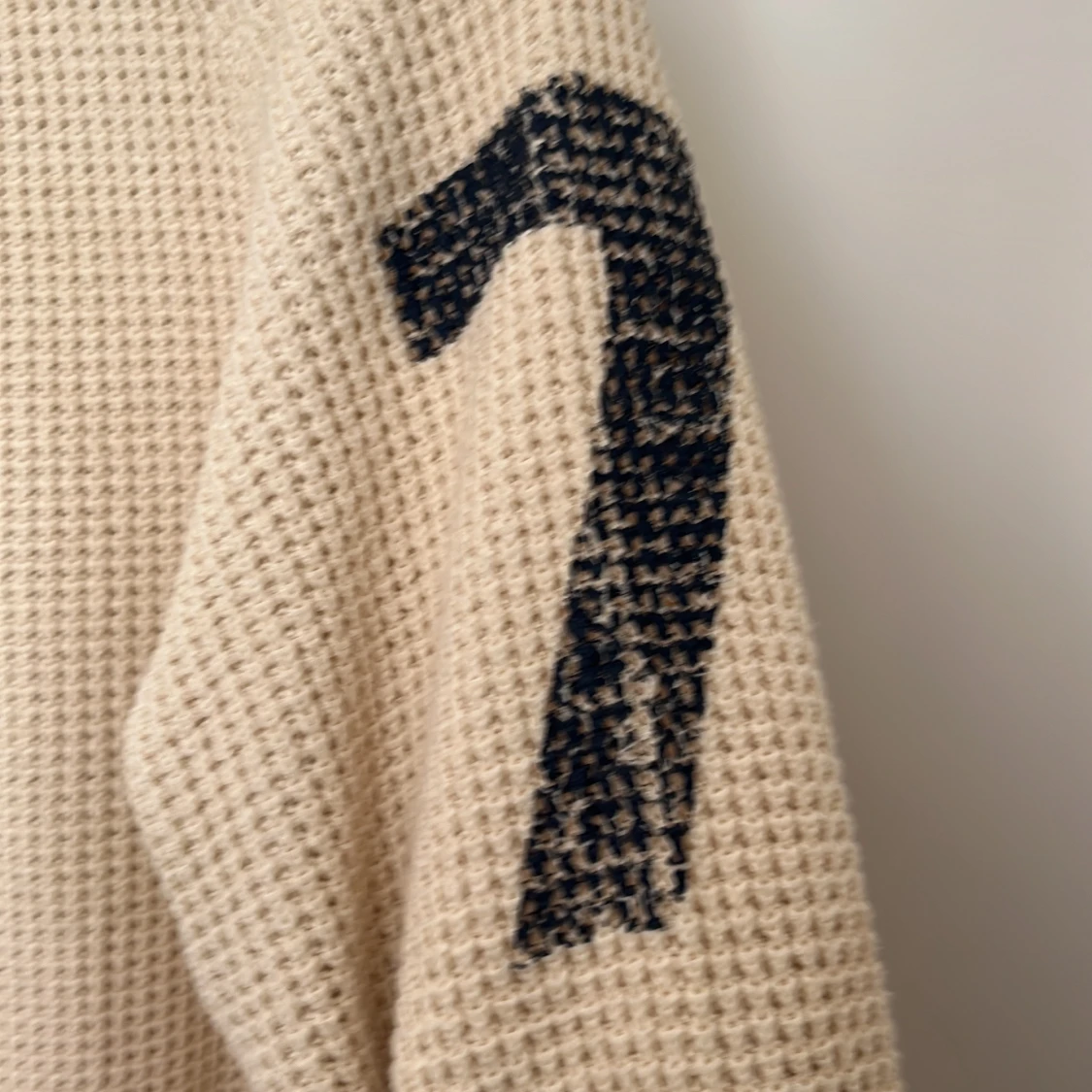 Beige stickad tröja med svarta siffror på ärmarna - 3