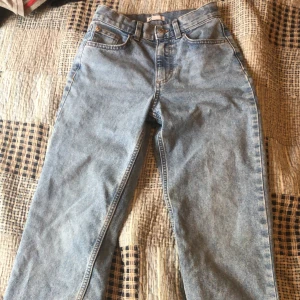 Ljusblåa raka jeans - Klassiska ljusblå jeans med raka ben och fem fickor. Byxorna har hög midja och stängs med dragkedja och knapp. Perfekta till vardags för en avslappnad stil.