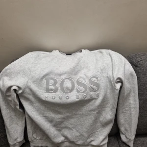 Fin Ljusgrå sweatshirt från Hugo Boss - Säljer en ny ljusgrå sweatshirt från Hugo Boss, haft den i 2 månader, helt felfritt tröja.