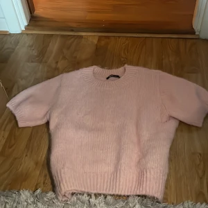 Ljusrosa stickad t-shirt från Gina Tricot - Supermjuk och fluffig ljusrosa stickad tröja från Gina Tricot. Tröjan har korta ärmar, rund halsringning och ribbade muddar. Den är mjuk i matrialet och inte alls stickig. Använd ca 2 gånger. Säljer pågrund av att den inte passar så bra på mig. Pris kan diskuteras. 