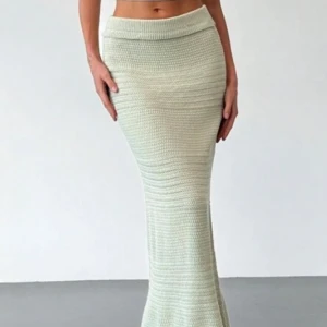 Ljusgrön stickad långkjol, går ner till fötterna - Säljer en ljusgrön stickad långkjol med bred resår i midjan. Kjolen har en åtsittande passform upptill och faller snyggt längs benen. Perfekt för dig som gillar en mjuk och bekväm stil. Helt ny aldrig använd 