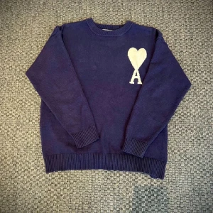 Ami Paris  - Mörkblå stickad tröja från Ami. Perfekt för dig som gillar stilrena looks