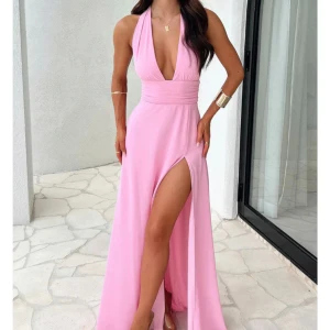 Klänning med slits - Säljer en ljusrosa långklänning med djup v-ringning och bred midjedetalj. Klänningen är ärmlös och har en hög slits framtill som ger en snygg och elegant look. Perfekt för speciella tillfällen! Skriv om ni vill ha mer bilder!!💕