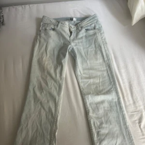 Ljusblå bootcut jeans med snygga fickor - Lågmidjade ljusblå jeans från hm. Fickor med knapp. Har sprättat ner längst ner på jeansen som man ser på sista bilden, går att ha kvar, sy upp eller klippa bort. 