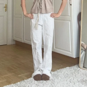 Vita raka linnebyxor - Snygga vita linnebyxor med rak passform och normal midja. Byxorna har en avslappnad stil och är perfekta för varmare dagar. De är lätta och luftiga, vilket gör dem sköna att bära hela dagen.