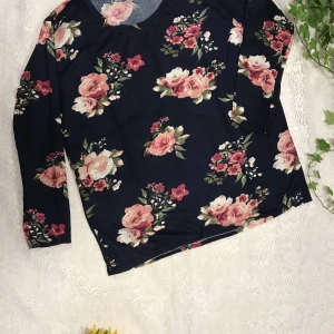 Svart blommig långärmad tröja - Svart långärmad tröja med stora rosa och röda blommor samt gröna blad. Mjuk och skön med rund halsringning, perfekt för dig som gillar romantiska mönster. Helt ny 99kr/st . Stlk S-M
