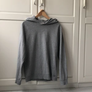 Grå hoodie från Jack & Jones - Säljer en enkel och stilren grå hoodie från Jack & Jones. Tröjan har lång ärm och huva, perfekt för en avslappnad look. Mjuk och bekväm bomullsblandning som passar året runt. Skriv privat för bättre bilder. Nypris cirka 450kr. Skriv om du har minsta fundering!