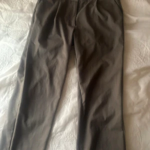 Grå kostymbyxor - Snygga grå kostymbyxor, Byxorna har en enkel midja och är tillverkade i ett mjukt material som ger en bekväm känsla.