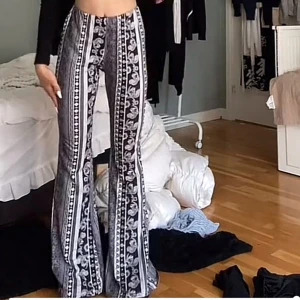 Svartvita utsvängda byxor med mönster - Säljer min snygga mönstrings utsvängda byxor med blommigt och randigt mönster. De är mycket stretchigt material som sitter tight upptill och blir vida nertill. Perfekta för fest eller bara mjukis byxor och extremt sköna och svalkade på sommaren🌸🤍🎉