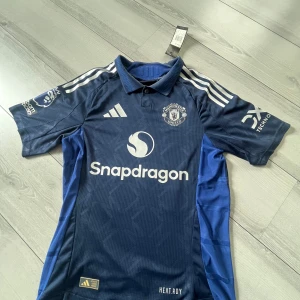 Manchester United bortatröja Mainoo 37 - Riktigt fin Manchester United borta tröja från 2024, aldrig använd se prislapp så riktigt bra skick, Large i barnstorlek