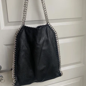 svart väska från tiamo - svart läderväska med en silverkedja ifrån TIAMO. :)
