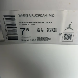 Nike Air Jordan 1 Mid i lila och turkos - Säljer ett par Nike Air Jordan 1 Mid i en cool färgkombination av lila och turkos med svarta detaljer. Skorna har klassisk snörning och en bekväm passform. Perfekta för dig som vill sticka ut med stil.