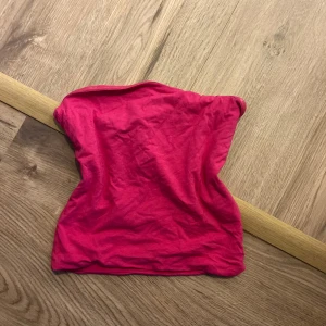 Rosa tubtopp - Säljer en snygg rosa tubtopp perfekt för sommardagar. Toppen är ärmlös och har en enkel design som gör den lätt att matcha med olika outfits. Perfekt för en avslappnad stil eller en dag på stranden.
