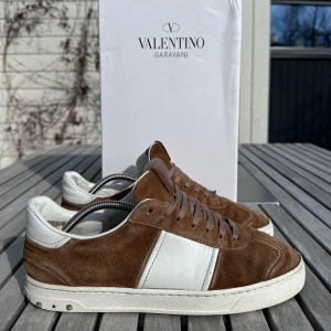 Valentino Flycrew guld/brun - Säljer nu mina guld/bruna valentino flycrew då dem endast står och samlar dam i min garderob. Väldigt bra skick 7,5/10 och endast 3 nitar. Box från mina gamla valentino open + dustbag, samt en reserv nit medkommer vid köp. Tveka inte på att skriva om ni har frågor!