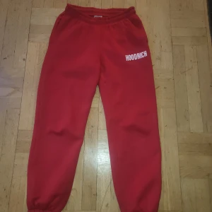 Röda mjukisbyxor från Hoodrich - Snygga röda mjukisbyxor från Hoodrich med elastisk midja och muddar vid bensluten. Byxorna har en avslappnad passform och är perfekta för en bekväm stil. Logotypen är tryckt på ena benet.