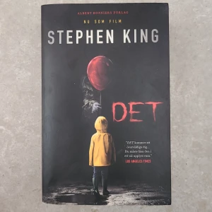 Det/It av Stephen King - Skräckroman av Stephen King. Omslaget visar en pojke i gul regnjacka med en röd ballong. Boken utforskar en skrämmande berättelse som sträcker sig över tjugoåtta år.