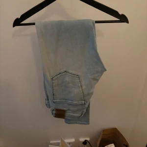 Ljusblå Anbass jeans från replay - Snygga ljusblå jeans från replay med en klassisk femficksdesign. De har en rak passform och är perfekta för en avslappnad stil. Jeansen har en knappgylf och en läderpatch med logotyp baktill. Stretchiga och slimfit. 