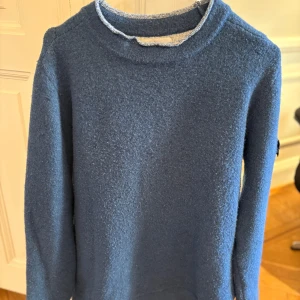 Stone island  tjocktröja - En cool tröja med en öppen sydd krage i blå, storlek S. Nypris ligger på ungefär 8000kr, säljer nu för 3500kr pris kan diskuteras vid snabbt köp.