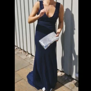 Mörkblå balklänning från TFNC London - Elegant mörkblå långklänning från TFNC London med v-ringning och spetsdetaljer på överdelen. Har prislappen kvar så är i nyskick!🥰