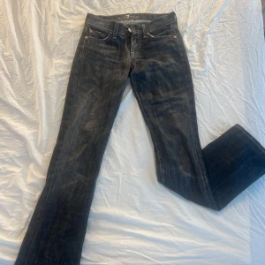 Mörkgrå jeans från 7 for All Mankind - Snygga mörkgrå jeans från 7 for All Mankind med en klassisk design. De har en bootcut-stil och är lågmidjade. Perfekta för en stilren look. Pris kan diskuteras💗