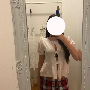 Ljusrosa blus med knytning - Säljer en gullig ljusrosa blus med korta ärmar och små rosetter från Gina tricot😍❣️helt ny och andvänt endast 3 gånger! Den är alldeles perfekt för sommaren🌊 Och storlek 146-152💌 Priset går att sänkas! 