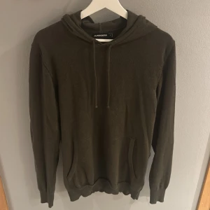 J.Lindberg stickad hoodie - Riktigt skön stickad hoodie från J.Lindberg i merinoull. Snygg mörkgrön färg. Säljer pga att jag inte använder den. 