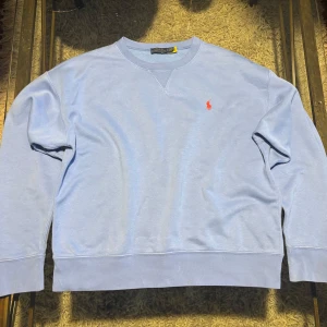 Blå sweatshirt från Polo Ralph Lauren - Säljer en stilren blå sweatshirt från Polo Ralph Lauren med det klassiska röda logotypbroderiet på bröstet. Den är i storlek M! 
