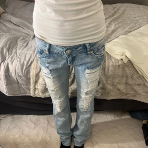 Utsvängda reviga jeans - Säljer ett par ljusa jeans med revor  och låg midja. Innerbsnlöngd 80, midja 37