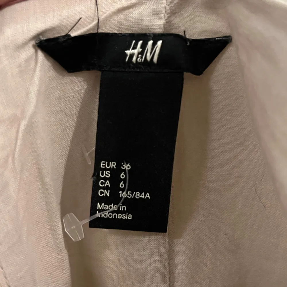 Säljer en söt klänning från H&M med beige korsett överdel och blommigt mönster i rosa och vitt på kjolen. Klänningen har smala axelband och dragkedja bak. . Mekot.