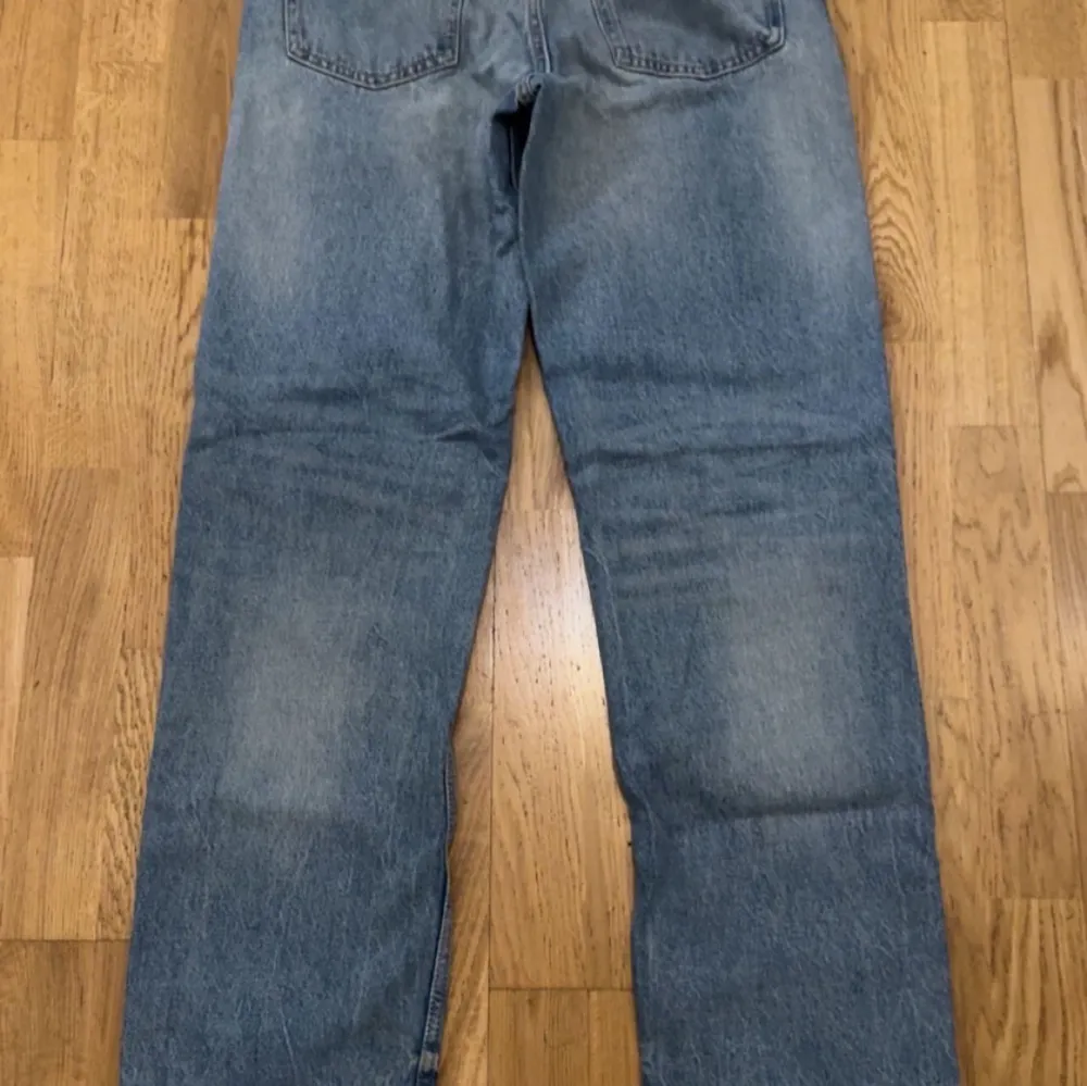 Säljer ett par klassiska blå jeansbyxor med en rak passform. De har en traditionell femficksdesign och en lätt tvättad look. Perfekta för en avslappnad stil.. Farkut & Housut.