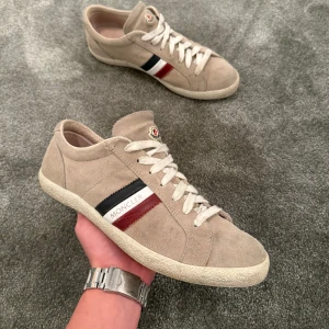 Moncler Skor - Säljer nu dessa riktigt feta Moncler skorna i storlek 41! De är i beige mocka och vit sula, helt perfekta till våren/sommaren! Skick: 9/10. Ingen box, därav pris. Hör av er vid minsta fundering⭐️💯