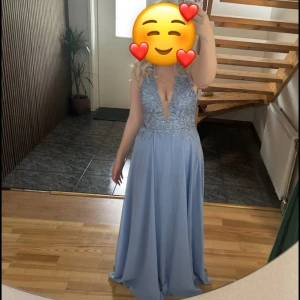 Ljusblå balklänning med spetsdetaljer - Säljer min balklänning. Den går att justera i midjan samt bysten. Passar mig perfekt på längden med klackar ( är 166 utan klackar) . Öppen i ryggen samt en slits. Använda en gång. 