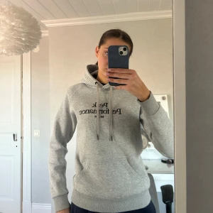 Grå hoodie från Peak Performance!! - Hej!! 💗Säljer en populär grå hoodie från Peak Performance med tryck framtill. Hoodien har en justerbar huva med snören och ribbade muddar vid ärmslut och nederkant. Superfin men säljs på grund av att den tyvärr inte kommer till användning. Den är i bra skick men har endast några defekter se bild 3 och 4, men inget man ser tydligt 💗 Den är i storlek M men sitter bra på mig som brukar ha strl S. Nypris 1299 kr. Kontakta gärna vid fler bilder eller funderingar!💗💗Pris går att diskuteras!!