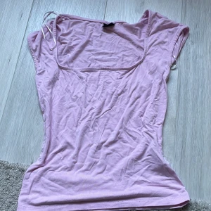 Rosa topp från Gina Tricot - Säljer en söt rosa topp från Gina Tricot. Toppen har en fyrkantig halsringning och är ärmlös, perfekt för varma dagar. Den är gjord i ett mjukt och bekvämt material.💕
