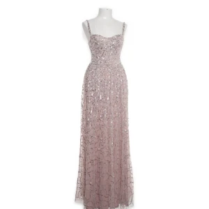 Glittrig långklänning i champagne - Säljer denna super fina bal klänningen jag köpte förra året för ca 2000. Klänningen är uppsydd några cm men släpar i marken på mig som är runt 1,65. Den upplagda delen går att sprätta bort.