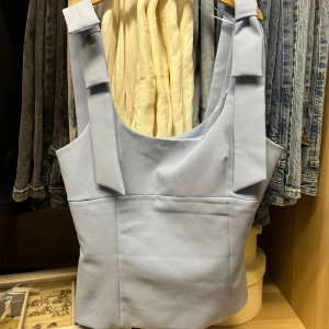 Ljusblå topp med rosetter från Zara - Säljer denna populära tröjan från Zara då jag råka köpa fel storlek och inte kunde lämna tillbaka den för jag köpte den i Italien. Den är bara använd en gång och är i jätte bra skick. 