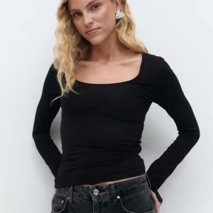 Svart långärmad topp - Säljer en svart långärmad topp med snygg i u ringning. Modellen är tight och passar perfekt till både jeans och kjol. Enkel och stilren design som funkar året runt.