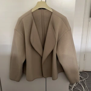 Beige jacka från Gina Tricot - Säljer en stilren beige jacka från Gina Tricot i storlek M. Jackan har en öppen front utan knäppning, lång ärm och mjukt, filtliknande material. Perfekt för dig som gillar en enkel och modern look🤩🤩hör av er vid frågor 