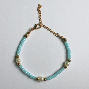 Färgglada armband med pärlor och gulddetaljer - Säljer tunna armband med små pärlor i pastellfärger: rosa, grön och blå. Armbanden har vita pärlor och guldfärgade detaljer samt justerbar kedja. Perfekt accessoar för att addera färg till din stil. Priset inkluderar alla armband på bilden. 