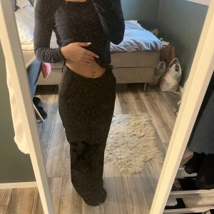 Svarta kostymbyxor med normal passform - Säljer ett par svarta kostymbyxor med normal passform och raka ben. Byxorna har hög midja och klassisk look, perfekta till många olika outfits. Snygga och stilrena, passar dig som gillar enkel och tidlös stil.