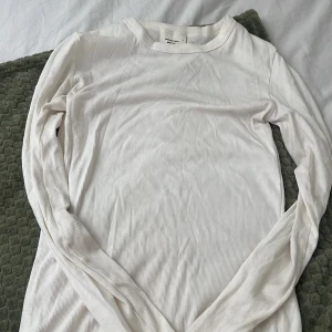 Vit ribbad långärmad tröja från Gina Tricot - Säljer en vit långärmad ribbad tröja från Gina Tricot, kollektionen Basically Basics. Perfekt som basplagg och enkel att matcha med olika outfits. Mjuk och stretchig i materialet för en bekväm passform.