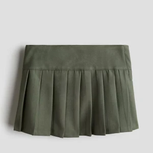 Olivgrön plisserad kjol från H&M - Säljer en olivgrön plisserad kjol från H&M med bred linning och knäppning i sidan. Kjolen har en klassisk kort modell. Perfekt för dig som gillar stilrena och enkla plagg. Aldrig använd. 