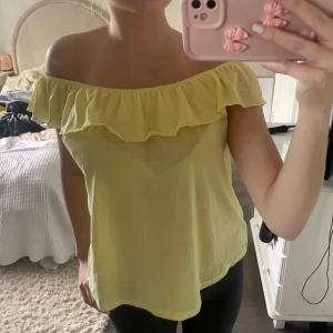 Gul offshoulder topp med volang - Säljer en söt gul offshoulder topp med volang. Super fin citron-gul färg! 