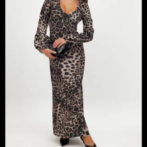 Söker denna i storlek M Eller L!!! - Snygg långklänning med leopardmönster och djup v-ringning. Klänningen har långa ärmar och figurnära passform, perfekt för dig som vill sticka ut. Styla med klackar och en clutch för en trendig look.