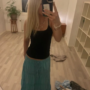 Turkos somrig långkjol - Säljer en turkos långkjol med små detaljer💙           Köpt utomlands och det är onesize men passar mig bra som brukar ha typ s och är 169cm lång 