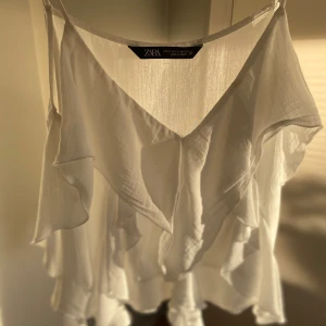 Vit volangblus från Zara - Super fin sommartopp från zara. Den är i toppen skick, fråga gärna om de är något eller be om fler bilder🩷