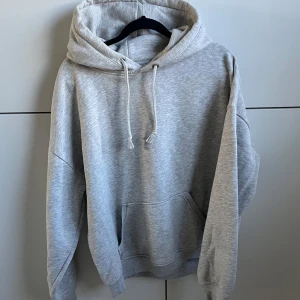 Grå hoodie med huva och ficka - Säljer en enkel och stilren grå hoodie.