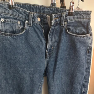 Blå jeans med rak passform WEEKDAY - Klassiska blå jeans med rak passform och fem fickor. Byxorna har normalhög midja, dragkedja och knapp framtill. Från Weekday