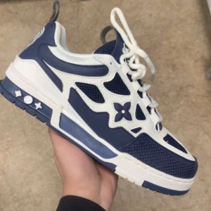 Lv skate - Säljer ett par Louis Vuitton LV Skate sneakers i blått och vitt. Skorna har en chunky sula, vita snören och detaljer med LV-logga och blommor. Tillverkade i en mix av skinn och syntetmaterial med coola mönster och kontrastpaneler.