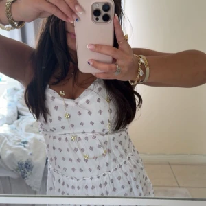 Sötaste sommarklänning med mönster - Söt vit klänning med mönster. Klänningen har smala axelband och en lätt utställd kjol som ger en luftig känsla. Perfekt för varma dagar och picknickar!🥰Den är köpt i en lokal butik i USA, använd en gång!💓 Skriv vid funderingar